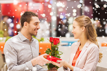 Image showing happy couple with present and flowers in mall