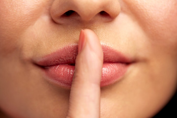 Image showing close up of young woman holding finger on lips