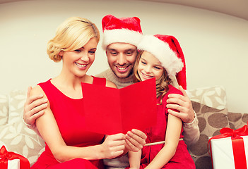 Image showing smiling family reading postcard