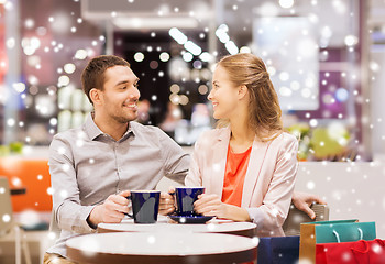 Image showing happy couple with shopping bags drinking coffee