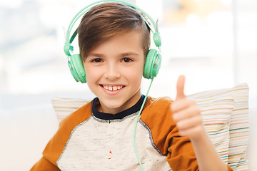 Image showing happy boy in headphones showing thumbs up at home