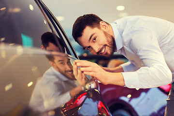 Image showing happy man touching car in auto show or salon