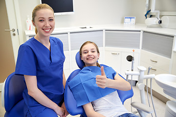 Image showing happy female dentist with patient girl at clinic