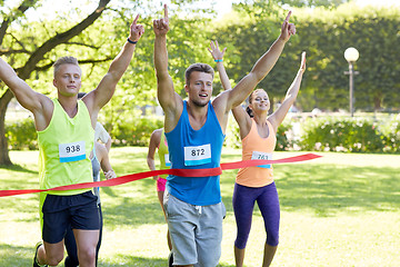 Image showing happy young male runner winning on race finish