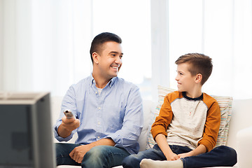 Image showing smiling father and son watching tv at home