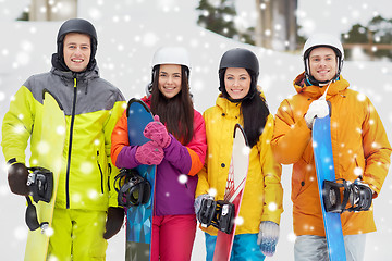 Image showing happy friends in helmets with snowboards