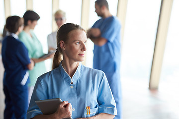 Image showing female doctor with tablet computer  standing in front of team