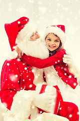 Image showing smiling girl hugging santa claus with gift at home