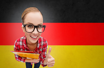 Image showing happy student girl with folders showing thumbs up