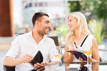 Image showing happy couple with wallet paying bill at restaurant