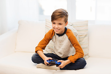 Image showing happy boy with joystick playing video game at home