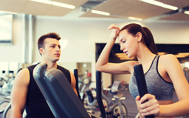 Image showing woman with trainer exercising on stepper in gym