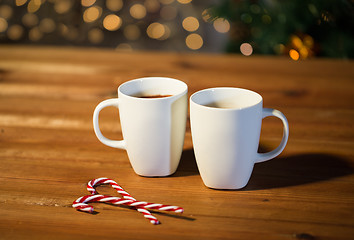 Image showing christmas candy canes and cups on wooden table