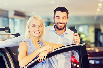 Image showing happy couple buying car in auto show or salon