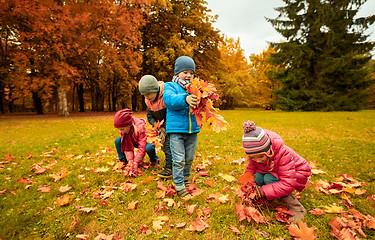 Image showing group of children collecting leaves in autumn park