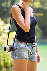Image showing Woman in nature with retro camera.