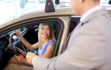 Image showing happy woman with car dealer in auto show or salon