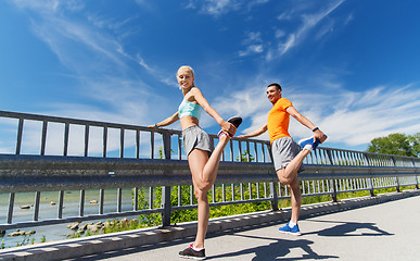 Image showing smiling couple stretching outdoors