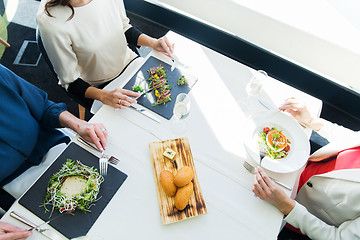 Image showing close up of women eating appetizer at restaurant
