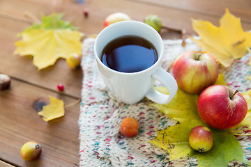 Image showing close up of tea cup on table with autumn leaves