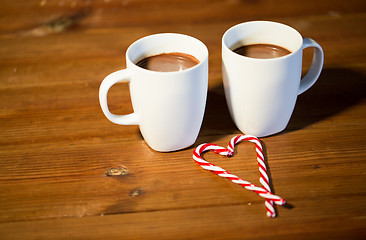 Image showing christmas candy canes and cups on wooden table