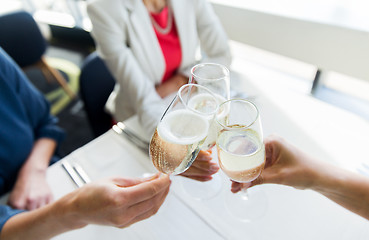 Image showing close up of women clinking champagne at restaurant