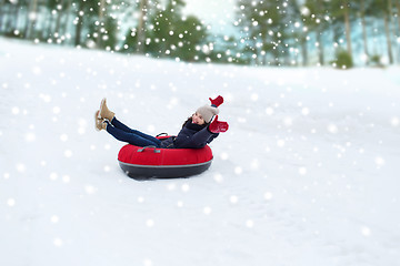 Image showing happy teenage girl sliding down on snow tube