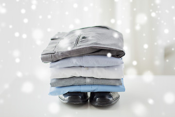 Image showing close up of male shirts, pants and shoes on table