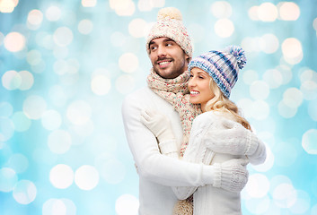 Image showing happy couple in winter clothes hugging over lights