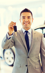 Image showing happy man showing key at auto show or car salon