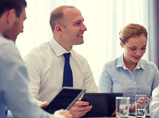 Image showing smiling businesspeople with tablet pc in office