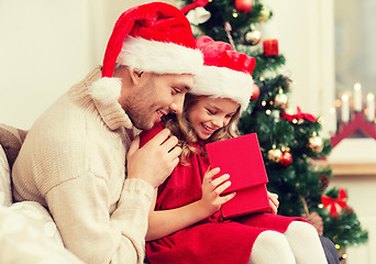 Image showing smiling father and daughter opening gift box