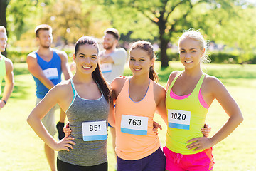 Image showing happy young sporty women with racing badge numbers