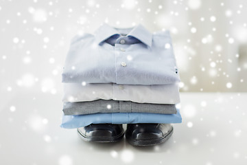 Image showing close up of folded male shirts and shoes on table