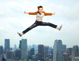 Image showing happy smiling boy jumping in air