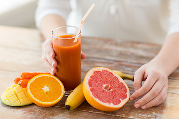 Image showing close up of woman hands with juice and fruits