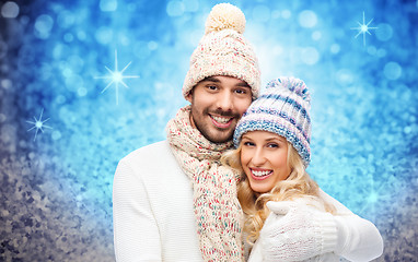 Image showing happy couple in winter clothes hugging over lights