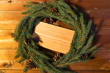 Image showing natural green fir branch wreath and wooden board