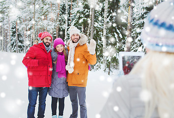 Image showing smiling friends with tablet pc in winter forest