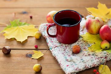 Image showing close up of tea cup on table with autumn leaves