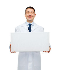 Image showing smiling male doctor holding white blank board