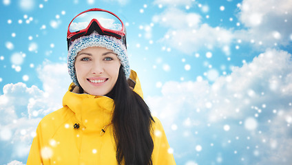 Image showing happy young woman in ski goggles over blue sky