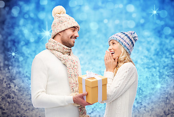 Image showing smiling couple in winter clothes with gift box