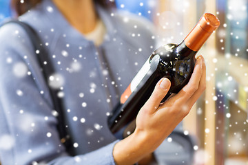 Image showing happy woman choosing and buying wine in market