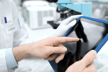 Image showing close up of scientists hands with tablet pc in lab