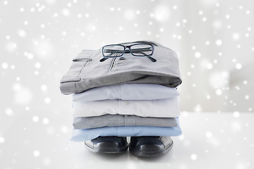 Image showing close up of folded male shirts and shoes on table