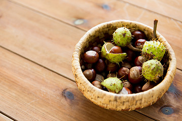 Image showing close up of chestnuts in basket on wooden table