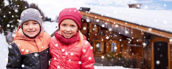 Image showing happy girl hugging boy over country house and snow