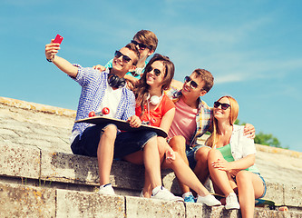 Image showing group of smiling friends with smartphone outdoors