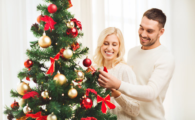 Image showing happy couple decorating christmas tree at home